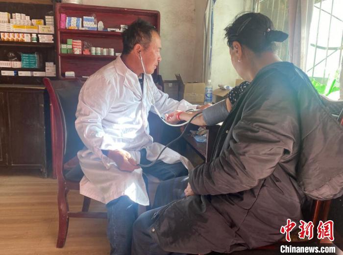 索木滾(左)為村民看病?！∪捞量h委宣傳部供圖