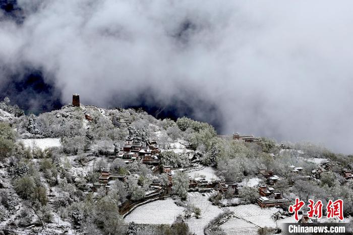 雪后的藏寨和碉樓構成美麗的雪景?！〗党鯘衫?攝