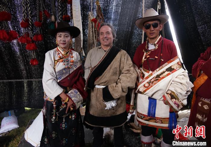 圖為一名外籍攝影師(中)身穿藏服和藏族民眾合影留念?！●R銘言 攝