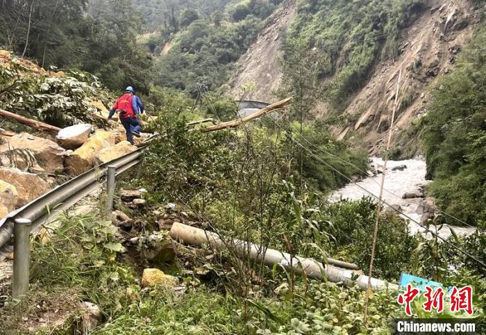 電力搶險人員快速通過危險路段，旁邊是受損的電力線路 四川電力供圖