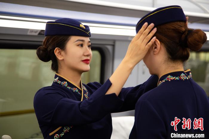 圖為青藏鐵路西格段“復興號”動車組乘務員互相整理新制服?！±罾?攝