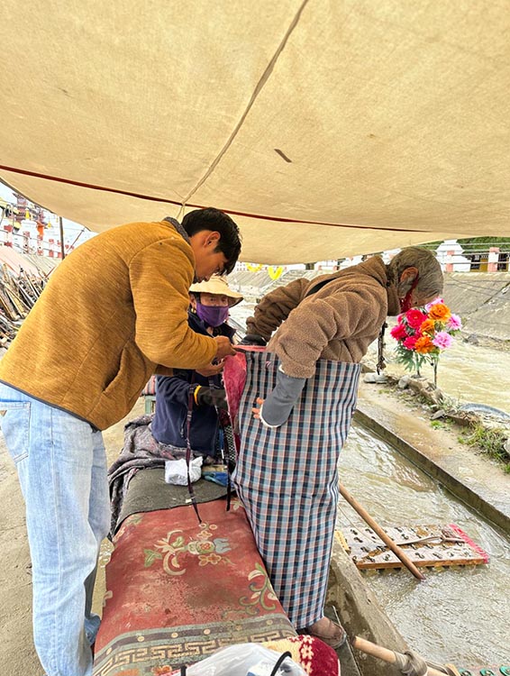 扎西奪爾登為路邊老人送去保暖圍腰。阿壩州文明辦供圖