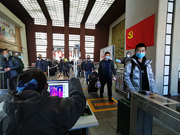 拉薩火車站工作人員對出站旅客進行紅外線測溫。趙越拍攝.jpg