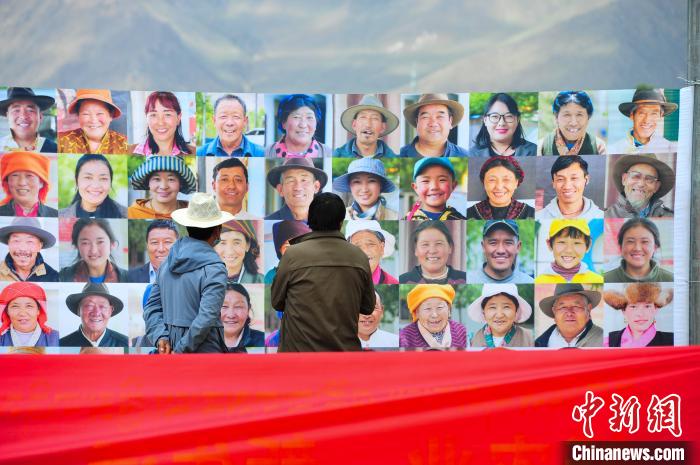 圖為當地民眾在觀看展板上的笑臉?！垈?攝