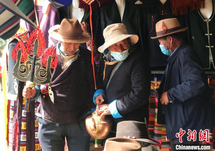 圖為三位藏族老人在集市上聊天交談?！∪轿木?攝