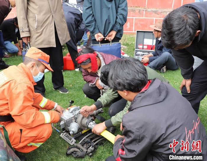 圖為森林消防員為護林員講解滅火裝備的使用方法?！〔际猩窒乐ш?供圖
