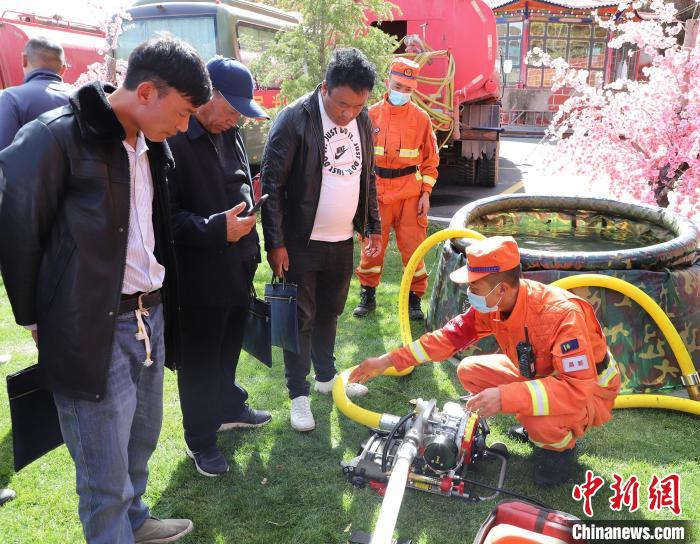 圖為森林消防員為護林員講解滅火裝備的使用方法?！〔际猩窒乐ш?供圖