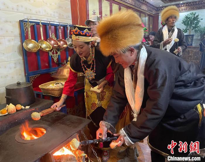 圖為人們在火上烤節日美食“結達”?！∪轿木?攝