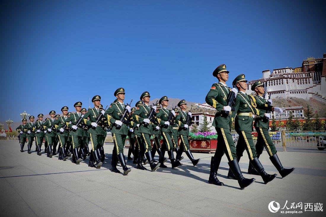 國旗護衛隊隊員緊握鋼槍，踏著威武雄壯的步伐，走向國旗臺。人民網 次仁羅布攝