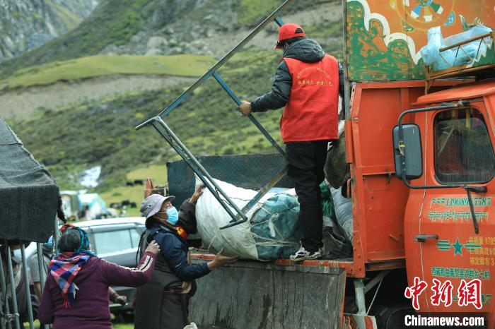 圖為工作人員幫助牧民們卸家具?！÷蹇?攝