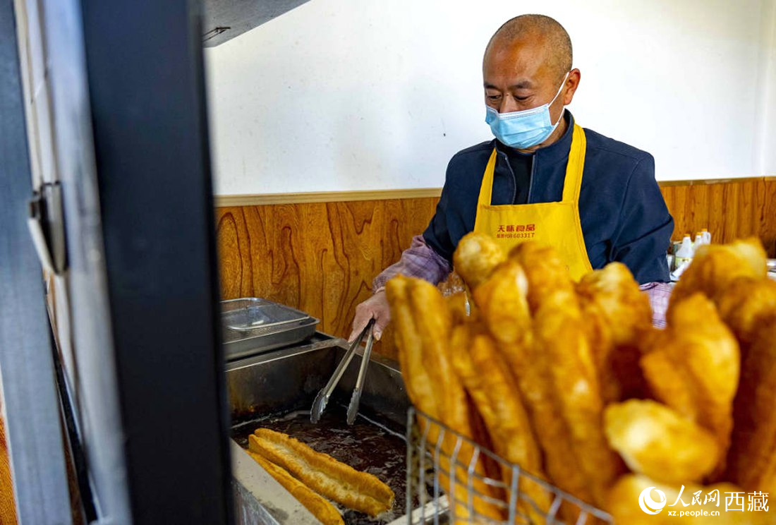 早餐店老板正在炸油條。人民網 次仁羅布攝