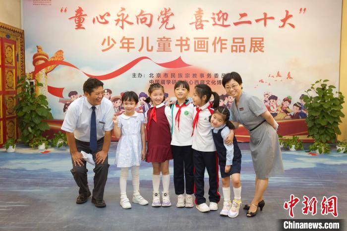 圖為與會嘉賓與入選畫作的“小作者”們在展覽上合影?！≈袊貙W研究中心供圖