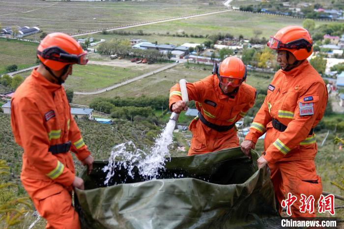 技能大練兵過程中，消防員在陡坡上向蓄水池注水?！±顕鵂c 攝