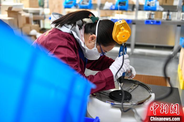 圖為工人正在組裝炊具?！∝暩聛硭?攝