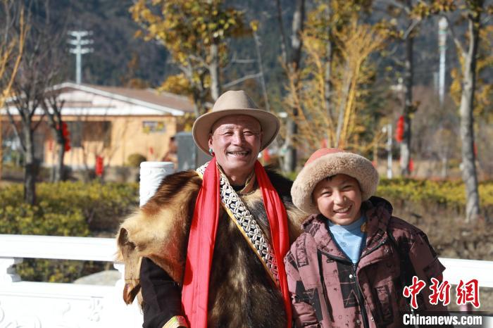 圖為林芝市巴宜區布久鄉仲果村村民桑杰與孫子一起參加藏歷新年活動?！埩?攝