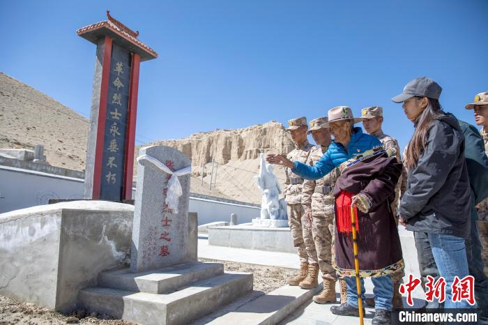圖為在西藏阿里地區札達縣烈士陵園，82歲的次仁南杰老人為軍民代表講述新舊西藏的變化?！詵| 攝