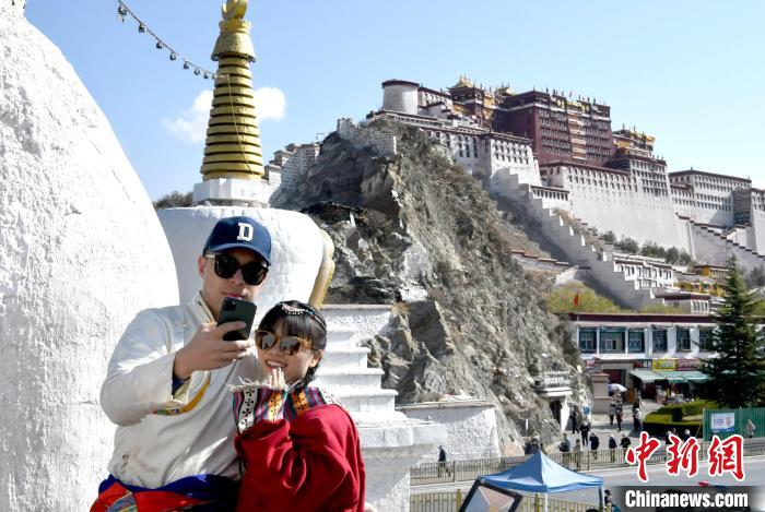 4月17日，游客身著藏式元素服裝在拉薩布達拉宮觀景臺拍照留念?！±盍?攝
