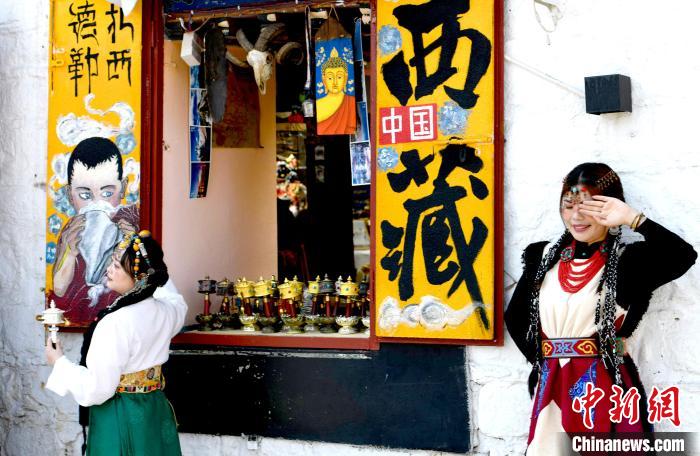 4月17日，游客身著藏式元素服裝在拉薩八廓街拍照留念?！±盍?攝
