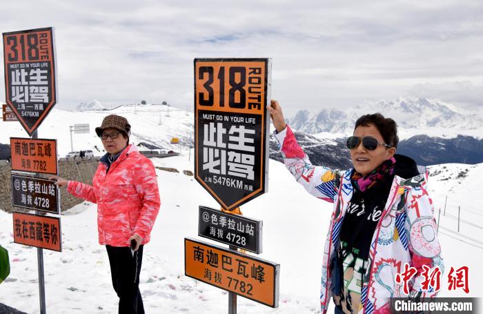 圖為5月14日，西藏林芝色季拉山觀景臺，游客與南迦巴瓦峰合影?！±盍?攝