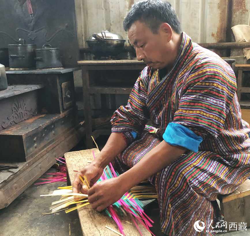 門巴族漢子愛明正在編織藤竹品。