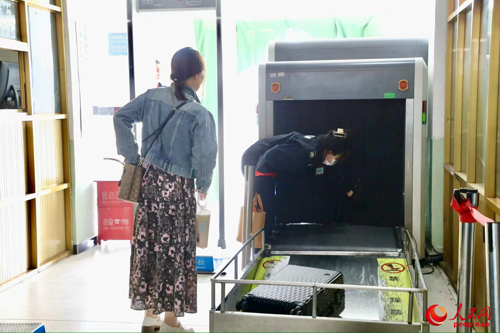 車站工作人員幫旅客提取行李。人民網記者 次仁羅布攝