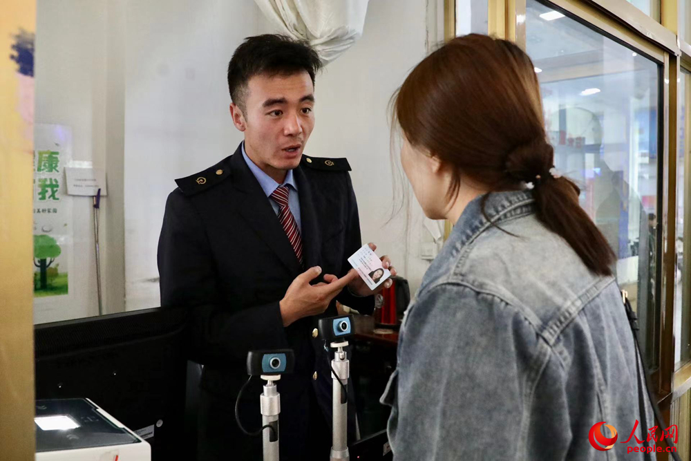 車站工作人員向旅客解答疑問。人民網記者 次仁羅布攝