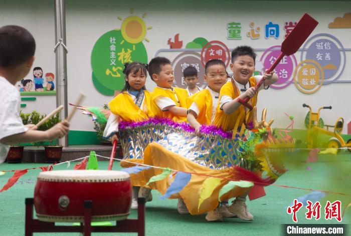 圖為龍舟賽游戲上，小伙伴們打鼓加油?！《^生 攝
