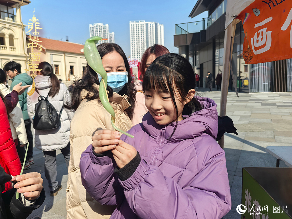 2025年1月29日，湖北武漢的新春廟會上，小朋友拿著吹制好的糖人，十分開心。人民網記者 張沛攝