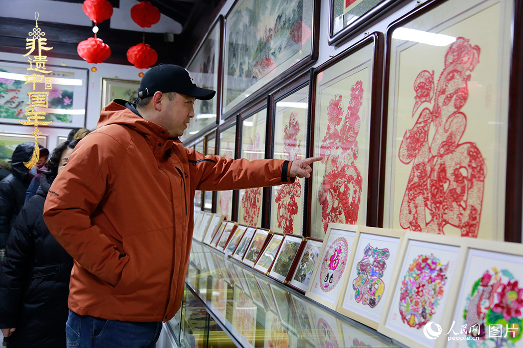 2025年1月23日，游客在天津楊柳青古鎮欣賞傳統剪紙作品，感受指尖上的古老藝術。人民網記者 崔新耀攝