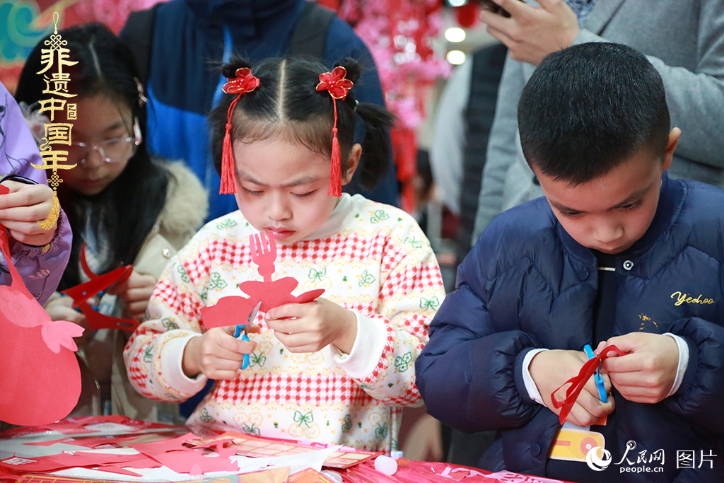 2025年1月23日，上海市青少年活動中心迎新春游園會上，小朋友們正在學習剪窗花。人民網記者 龔莎攝