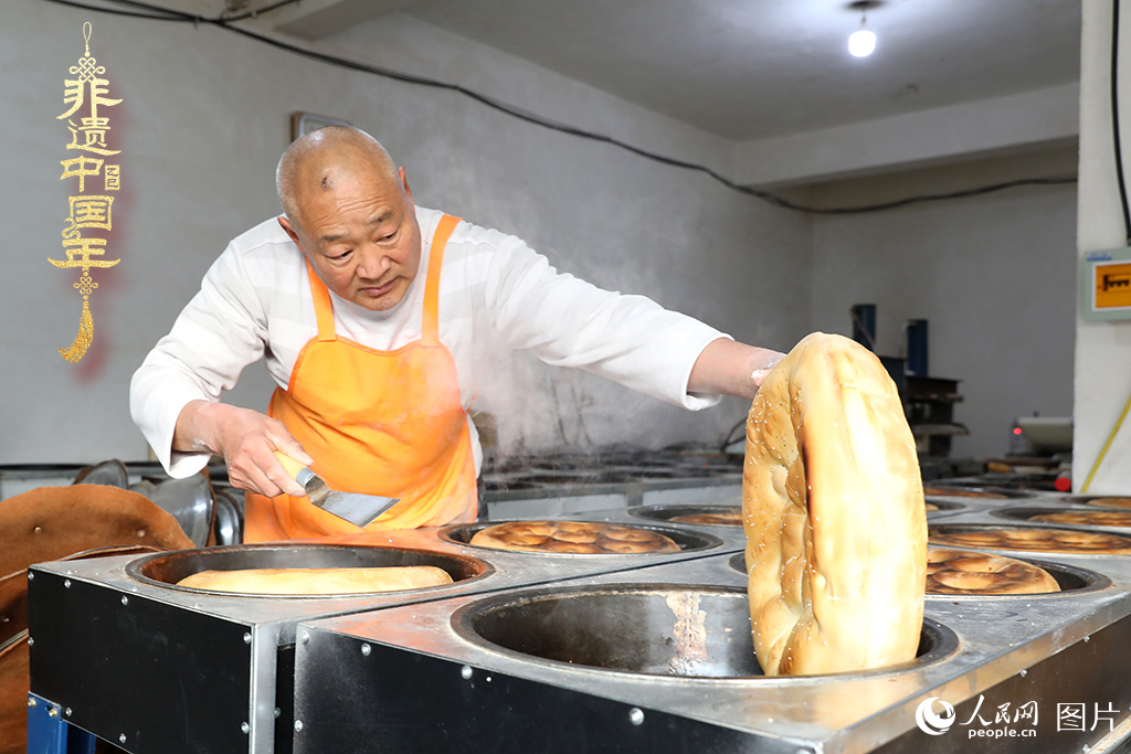 2025年1月23日，山東省臨沂市莒南縣一家傳統大餅作坊內，師傅們正忙著烤制當地人春節期間家家戶戶必備的、金黃誘人的莒南大餅。人民網記者 劉祺攝