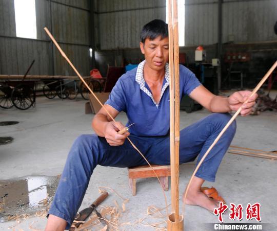 貧困戶韋志在制作宮燈燈架。他在韋軍民的幫助下日子越過越有盼頭?！∈Y雪林 攝