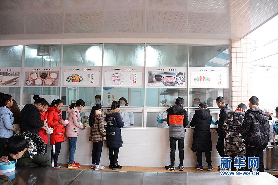 1月3日，重慶南川區北固中學學生在食堂排隊打飯。學校每周菜譜會隨著時令季節和營養要求,按照“兩葷兩素”的標準來搭配。新華網趙紫東攝