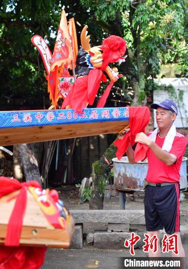 圖為5月29日，長樂江田鎮村民為即將入水的新龍舟系紅布?！埍?攝