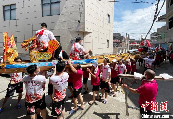 圖為5月29日，長樂江田鎮村民們肩扛著新龍舟舉行入水前游街儀式?！埍?攝